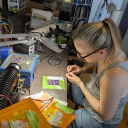 Kris working on a circuit board at her desk